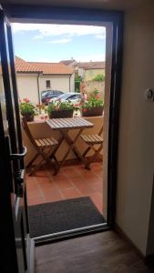 a door open to a patio with a table and chairs at Chez Francine La Chenevière in Saint-Rémy-de-Chargnat