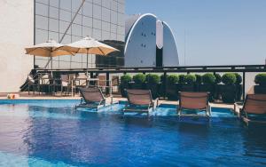 a swimming pool with umbrellas in the middle of it at Cullinan Hplus Premium in Brasília