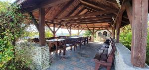 a wooden pavilion with wooden tables and benches under it at Agroturystyka Skalny Widok in Hucisko
