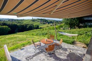 a patio with a table and chairs under a large umbrella at House Thara Studio Apartments in Štrigova +8 photos