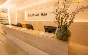 a room with two tables and a wall with a sign on it at Cullinan Hplus Premium in Brasília