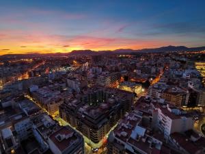 una vista aérea de una ciudad por la noche en Sky Suites Alicante, en Alicante