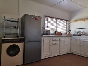 a kitchen with a refrigerator and a dishwasher at Kayser's Sea Breeze in East London +22 photos