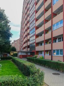 um edifício de apartamentos com um jardim em frente em INITIUM rooms - Pokoje na wynajem - Obrońców Wybrzeża 4D em Gdansk