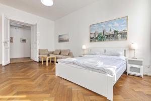 プラハにあるAparthotel Wenceslasの白いベッドルーム(ベッド1台、ソファ付)