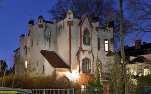 an old castle building with the sun shining on it at Lilienthalschlösschen in Berlin