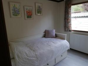 a bedroom with a bed with a pillow on it at Roodborstje 4 persoonschalet Putten in Putten