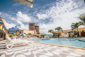a swimming pool with lounge chairs and umbrellas at Hotel Triângulo in Caldas Novas +52 photos