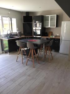 a kitchen with a table and chairs and a refrigerator at La Grange du Pont in Civray-de-Touraine