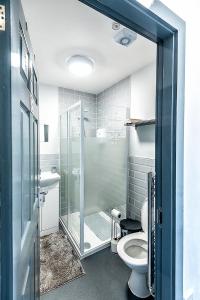 uma casa de banho com uma cabina de duche em vidro e um WC. em The Anfield Rooms em Liverpool