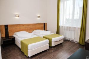 a hotel room with two beds and two lamps at Deluxe 2 Hotel in Almetyevsk