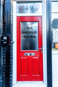 a red door with a sign on it at The Anfield Rooms in Liverpool