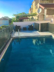 una piscina de agua azul frente a un edificio en Apartment Pero&Mika With Swimming Pool, en Dubrovnik