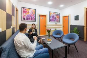 a man and a woman sitting in a waiting room at Etude Hotel in Lviv