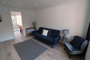 sala de estar con sofá azul y silla en Amaya Three - Newly Renovated - Sleeps 6 - Grantham, en Grantham