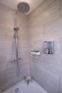 Das Bad ist mit einer Dusche und einer Badewanne ausgestattet. in der Unterkunft Amaya Three - Newly Renovated - Sleeps 6 - Grantham in Grantham