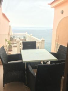 een tafel en stoelen met uitzicht op de oceaan bij Seaview in Acantilado de los Gigantes
