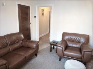 a living room with two leather couches and a table at Richmond Luxury flat Fabulous location in Southend-on-Sea