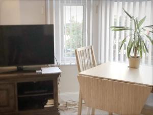 a living room with a table and a flat screen tv at Richmond Luxury flat Fabulous location in Southend-on-Sea