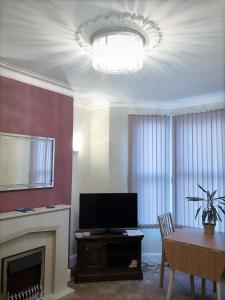 a living room with a fireplace and a television at Richmond Luxury flat Fabulous location in Southend-on-Sea