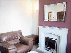 a living room with a leather chair and a mirror at Richmond Luxury flat Fabulous location in Southend-on-Sea