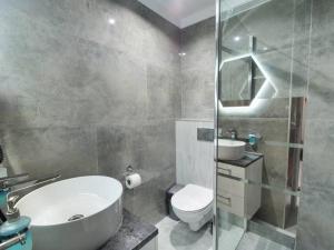 La salle de bains est pourvue d'un lavabo, de toilettes et d'une douche. dans l'établissement Pokoje Gościnne Zborowski & Wnuki, à Dźwirzyno