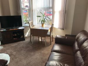 a living room with a table and a leather couch at Richmond Luxury flat Fabulous location in Southend-on-Sea