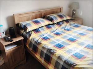 a bed with a colorful comforter and a night stand at Richmond Luxury flat Fabulous location in Southend-on-Sea