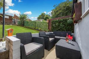 d'une terrasse avec des chaises en osier et une table. dans l'établissement Cosy 3 Bedroom House - Private & Central - Ultra WiFi, à Canterbury