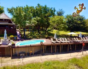 
a patio area with a pool and a fence at Sabie River Bush Lodge in Hazyview

