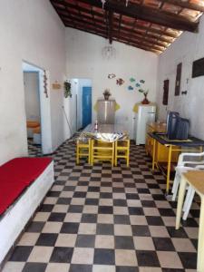 Cette chambre dispose d'un sol en damier avec une table et des chaises. dans l'établissement Casa de praia rústica, à Luis Correia