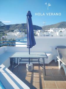 um guarda-chuva azul sentado numa mesa na varanda em Arto Blanco em Agua Amarga