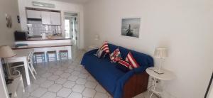 ein Wohnzimmer mit einem blauen Sofa und einer Küche in der Unterkunft Best Sea View Monte Gordo in Monte Gordo