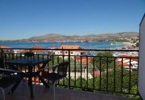 einen Balkon mit einem Tisch und Stühlen sowie Blick auf das Wasser in der Unterkunft Apartments Mara - 70m from the sea in Trogir