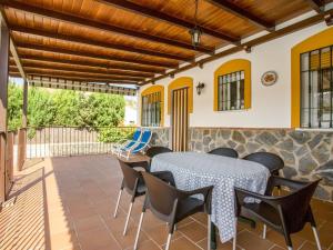 een eetkamer met een tafel en stoelen op een patio bij Belvilla by OYO La Vista in Guaro