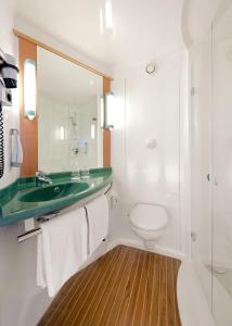 a bathroom with a green sink and a toilet at Ibis Budget Valencia Aeropuerto in Manises