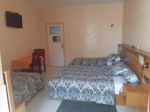 a bedroom with two beds and a table and a desk at HOTEL VELLEDA in Rabat