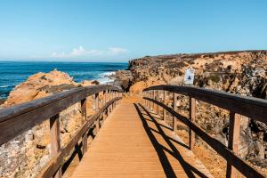 ペニシェにあるCasa Alegria by CosyCasa Praia Penicheの崖の上の海へ続く木造遊歩道