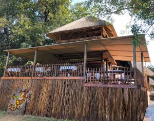 a pavilion with tables and chairs on a fence at Sabie River Bush Lodge in Hazyview