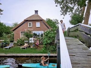 a woman standing on a bridge over a body of water at The Black Sheep Hostel in Giethoorn