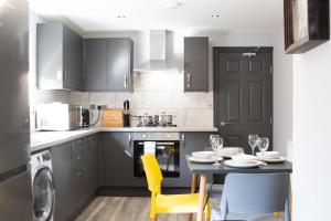a kitchen with a dining table and yellow chairs at Central location for contractors, families and business travellers Ashford in Ashford