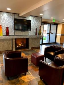 a lobby with a fireplace and leather chairs and a television at GetAways at Park Regency Resort in Park City