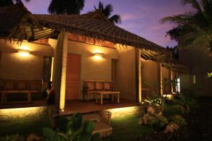 a house with a porch at night with lights at Bale Karang Cottages in Batukaras