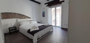 a bedroom with a white bed and a large window at Belle Donne Apartment in Benevento