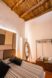 - une chambre avec un grand lit et un miroir dans l'établissement Vinto House Salerno Old Town, à Salerne