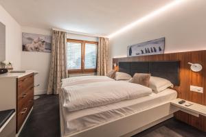 a bedroom with a large bed and a sink at Central & Elegant Apartments,partially with Fireplace, by Zermatt Rental in Zermatt