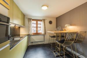 - une cuisine avec une petite table et des chaises dans l'établissement Central & Elegant Apartments,partially with Fireplace, by Zermatt Rental, à Zermatt