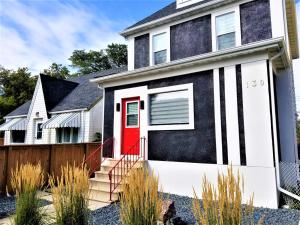 una casa en blanco y negro con una puerta roja en Hawaii-Peg en Winnipeg