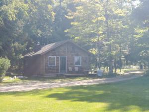 una pequeña casa de ladrillo en medio de un campo en Steffen's Cedar Lodge 
