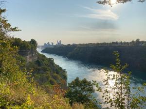 a view of a river with trees and a bridge at Cozy 4 Bedroom Home Accommodates 10 in Niagara USA in Niagara Falls